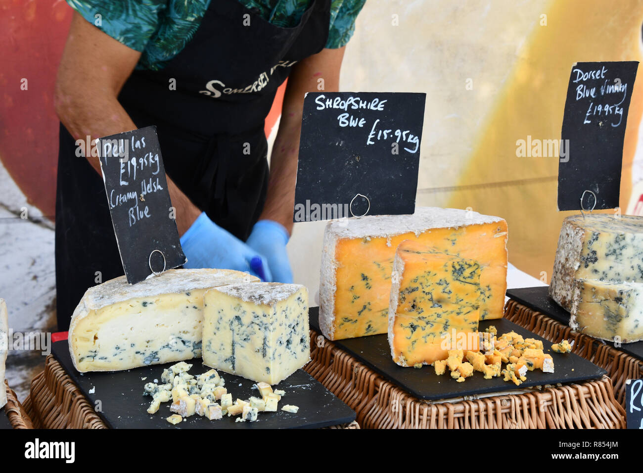 Blue Cheeses on market stall displayed with samples for tasting