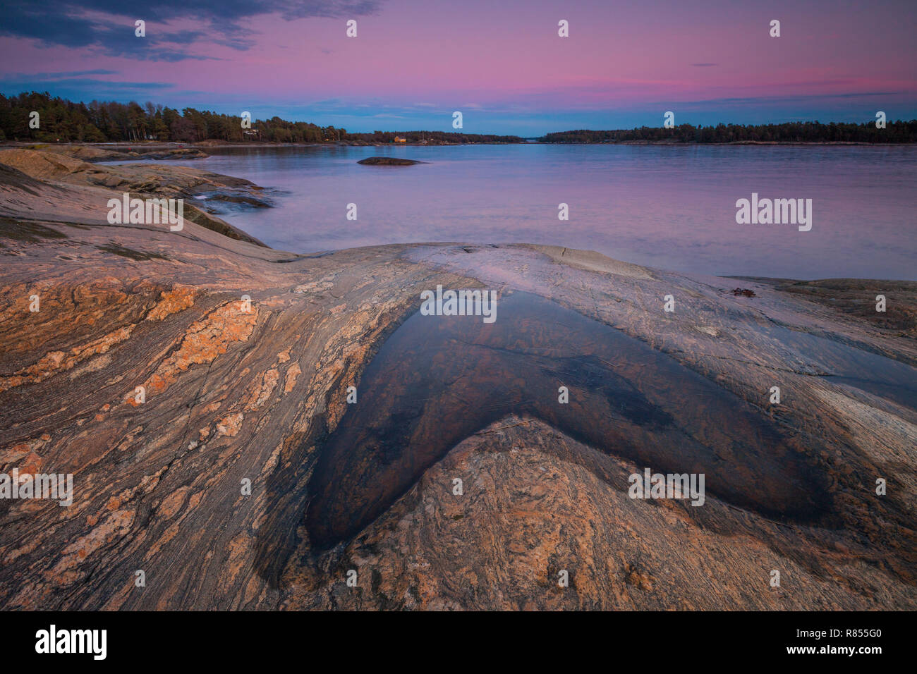 Beautiful winter evening landscape by the Oslofjord, at Oven in Østfold, Norway. The blue part on the sky is the shadow of the earth. Stock Photo