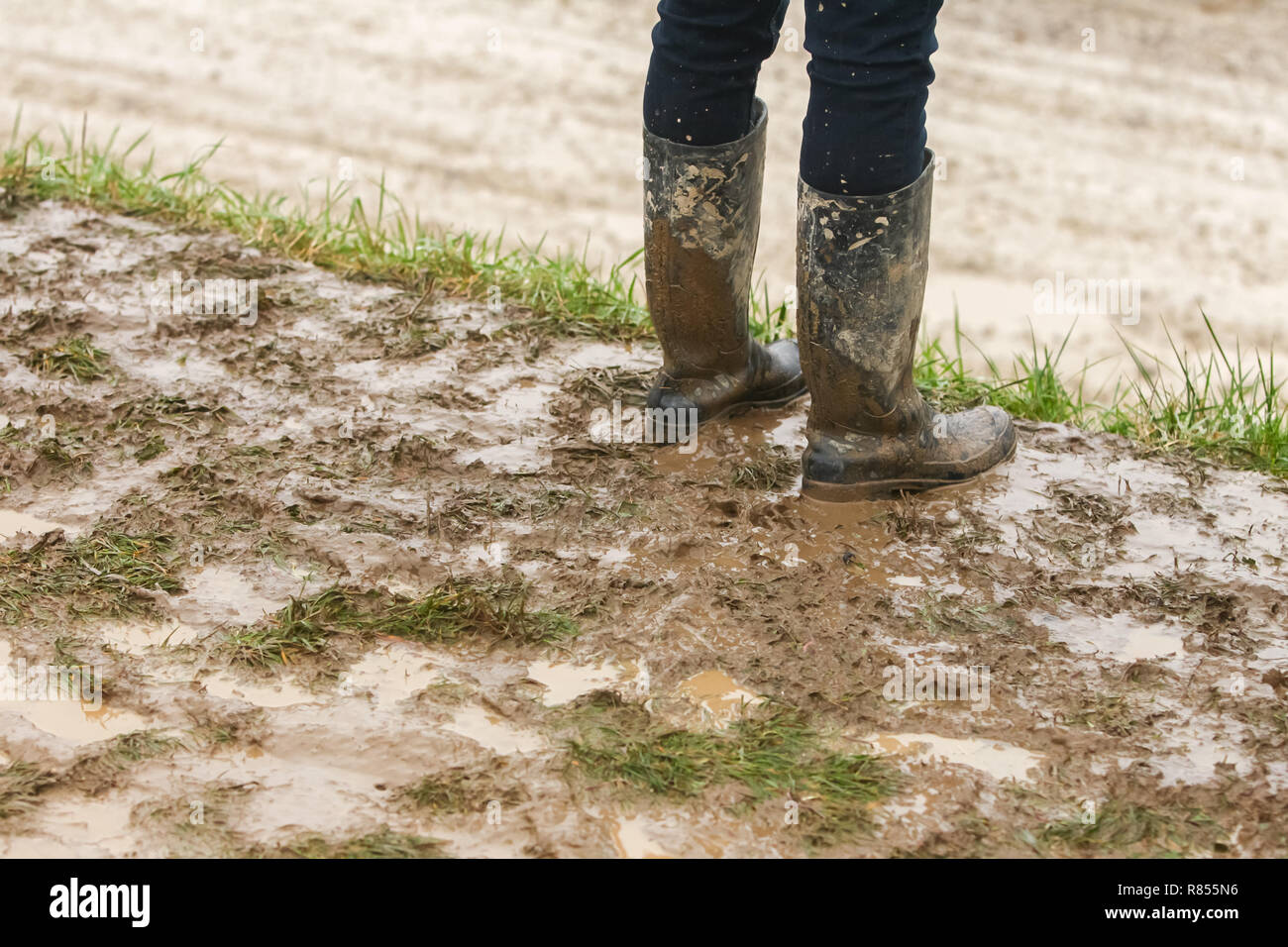 A person in rubber boots standing in the mud Stock Photo - Alamy