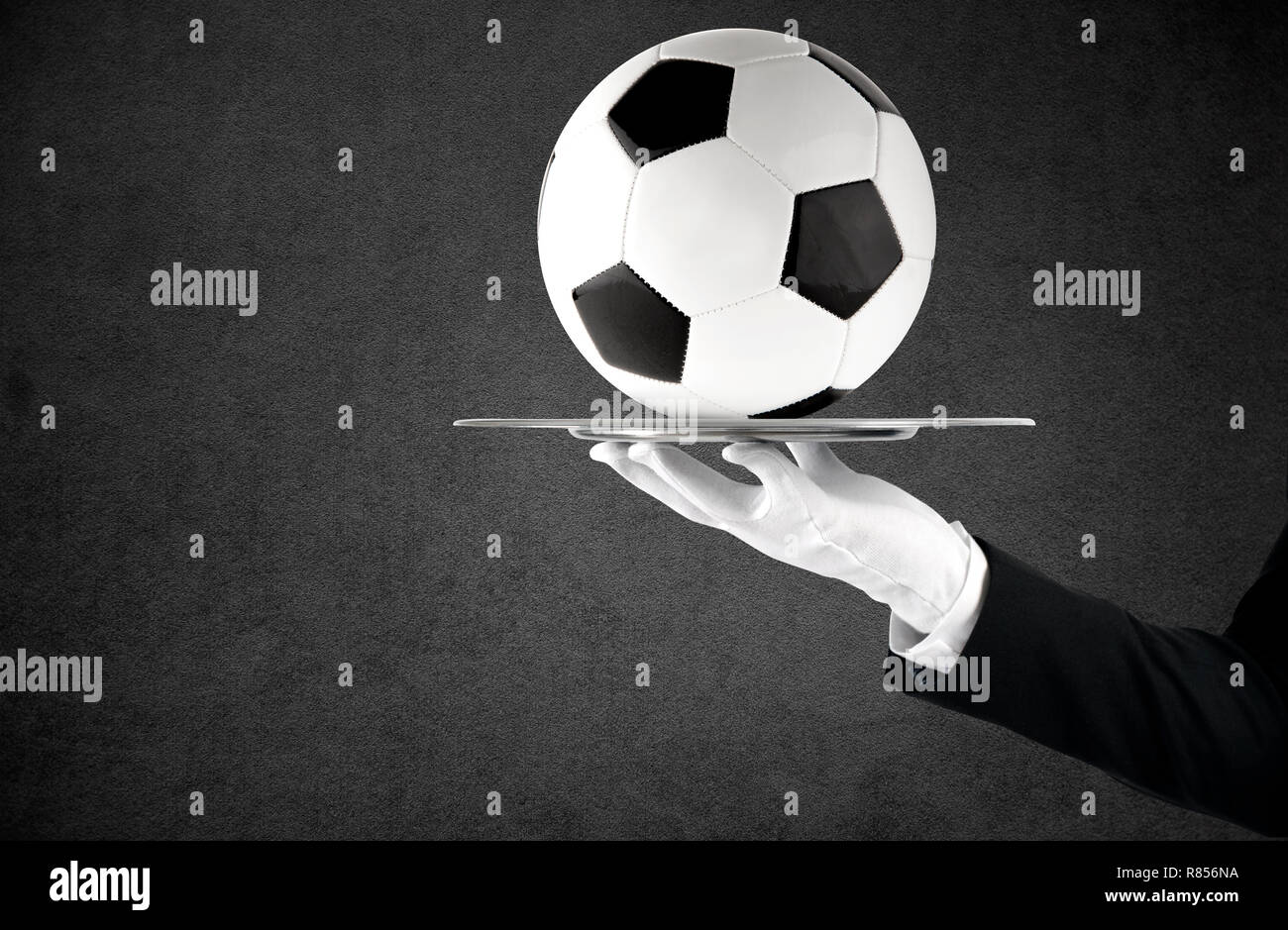 Waiter that holds a tray with soccer ball. Concept of first class service on soccer Stock Photo