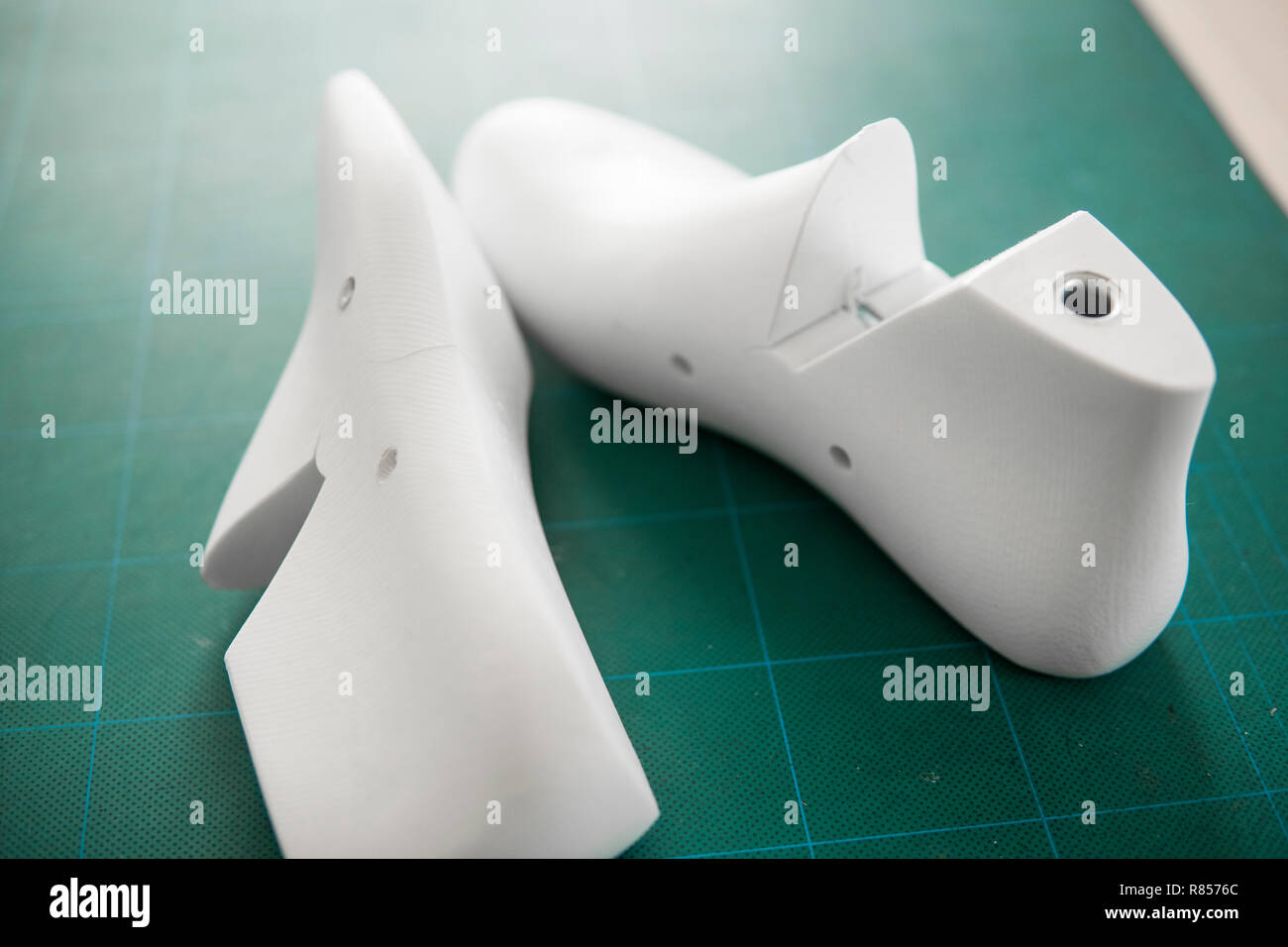 Two white plastic last shoe on rubber secondary cut cutting mat, The equipment used for shoe design Stock Photo