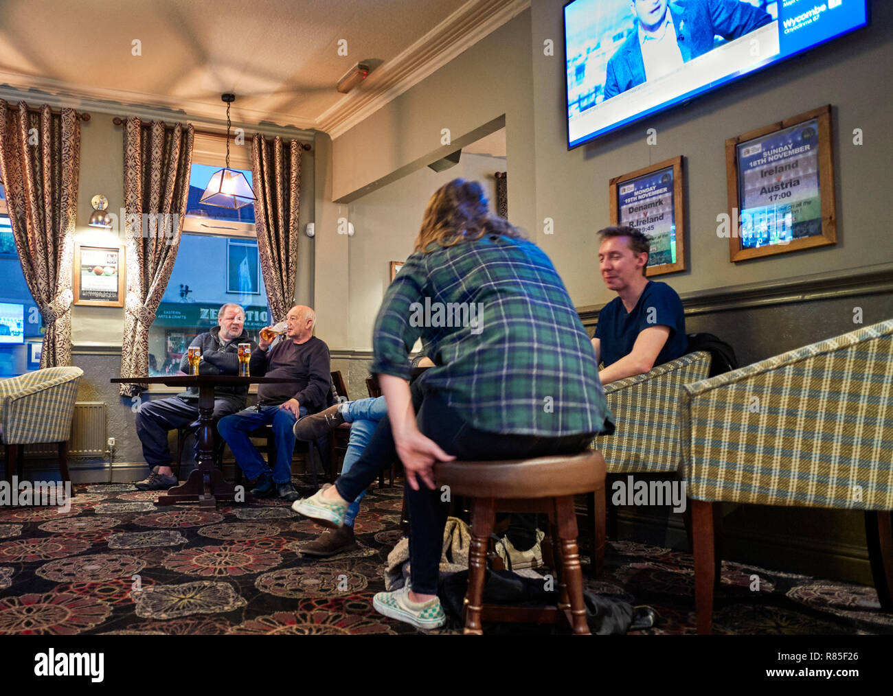 Watching sport on a Saturday afternoon in a pub with TV screens and patterned carpet Stock Photo