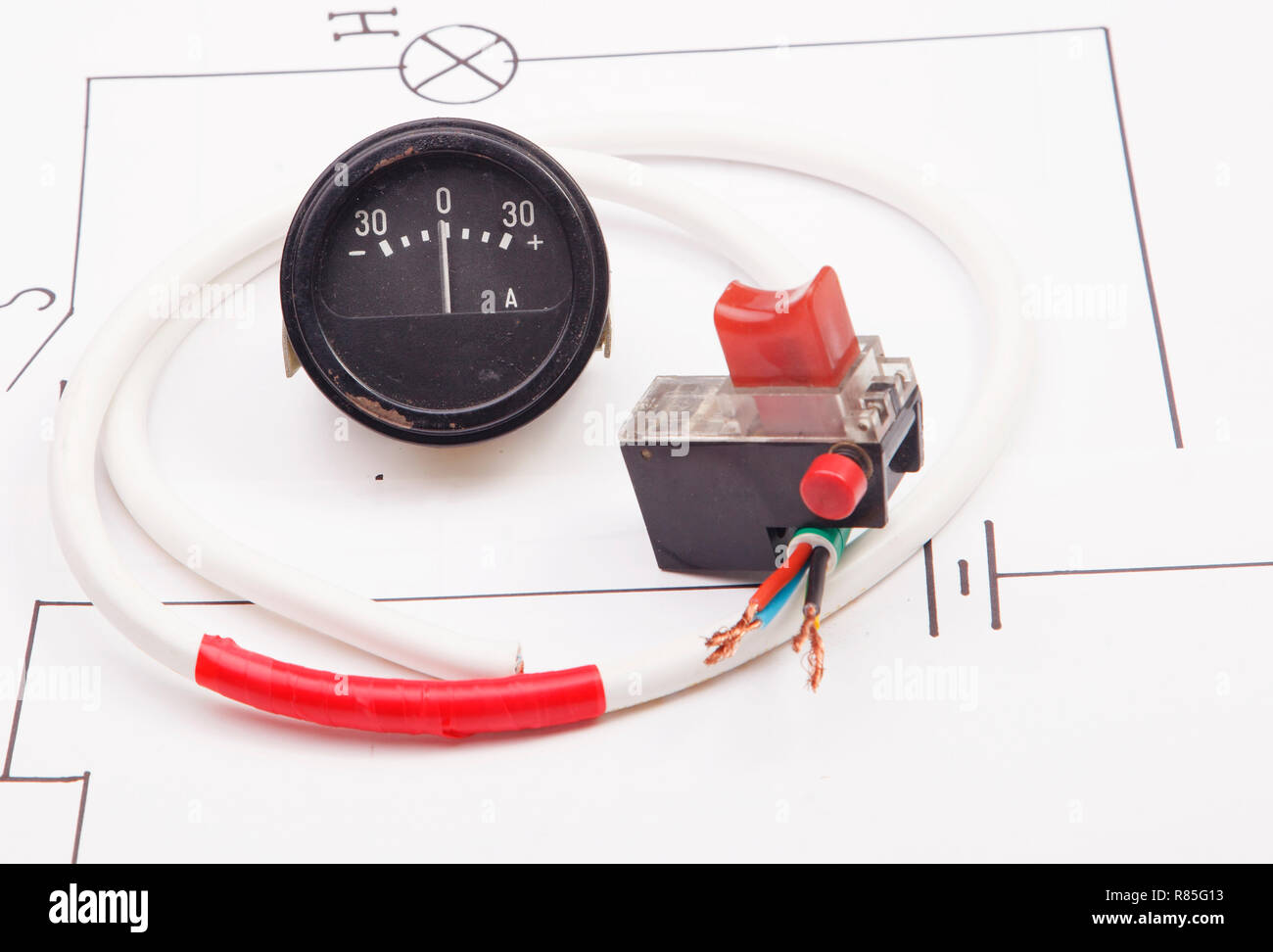 Ammeter and red start button on a background of the electric scheme Stock Photo