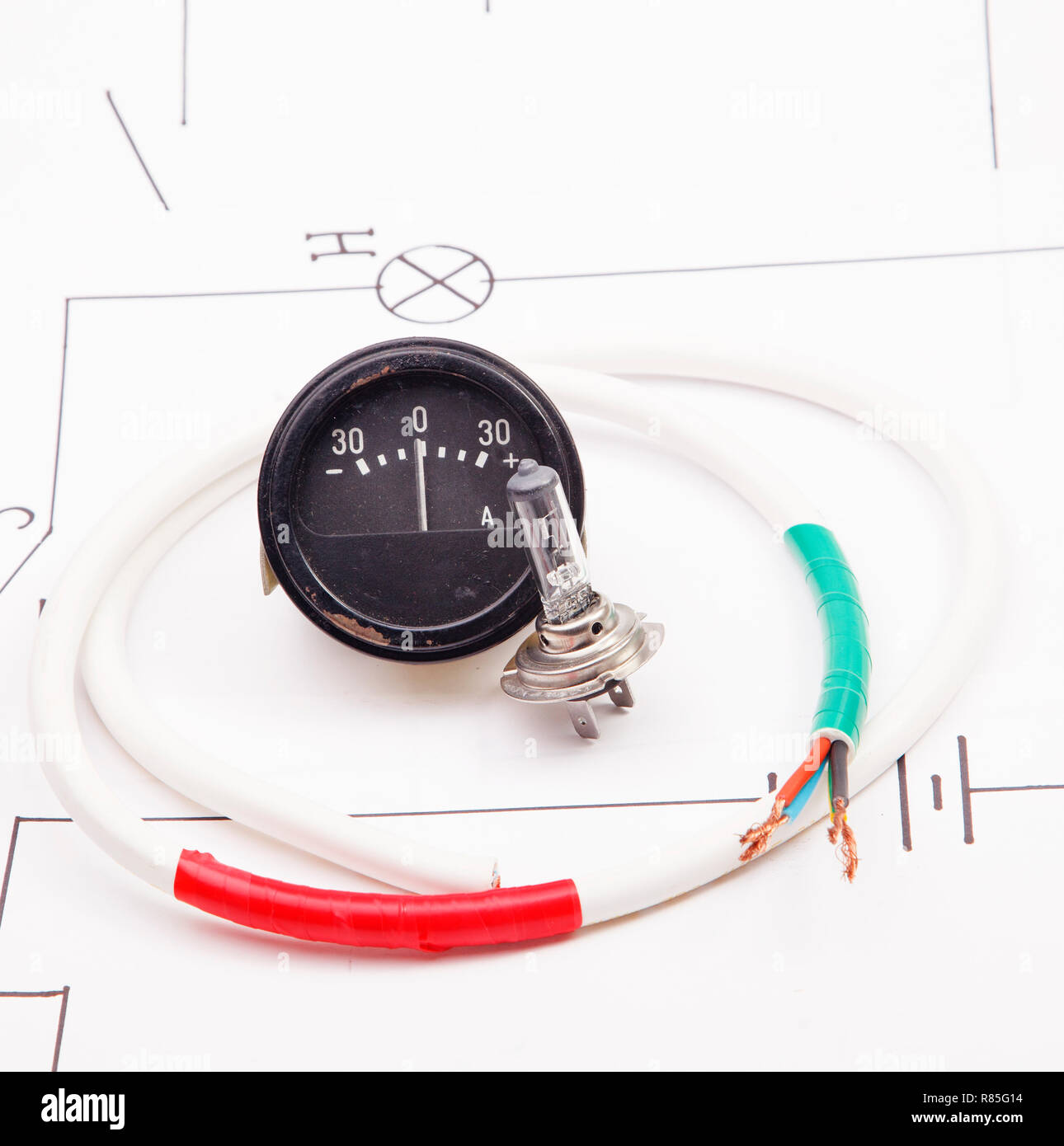 Ammeter and automobile lamp on a background of the electric scheme Stock Photo