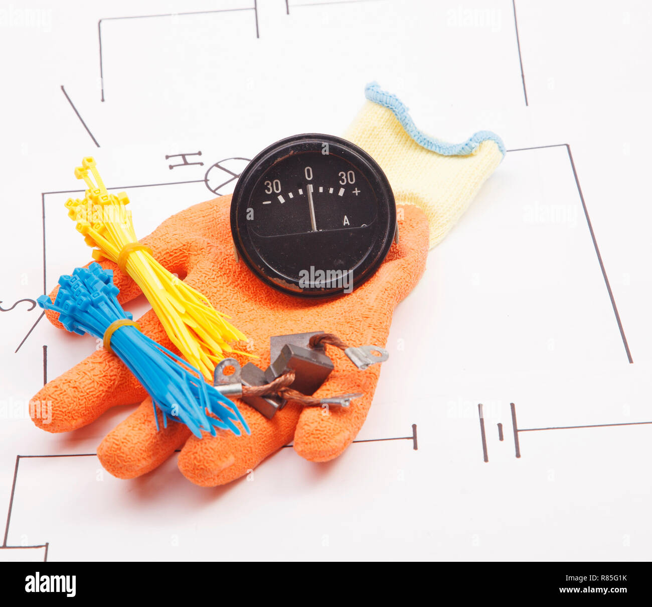 Ammeter and mounting gloves on a background of the electric scheme Stock Photo