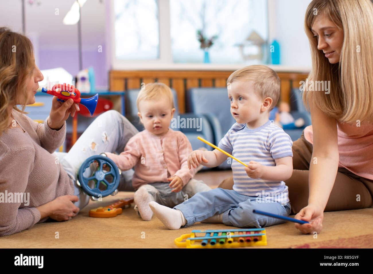 Musical education for preschoolers. Parents playing musical toys with