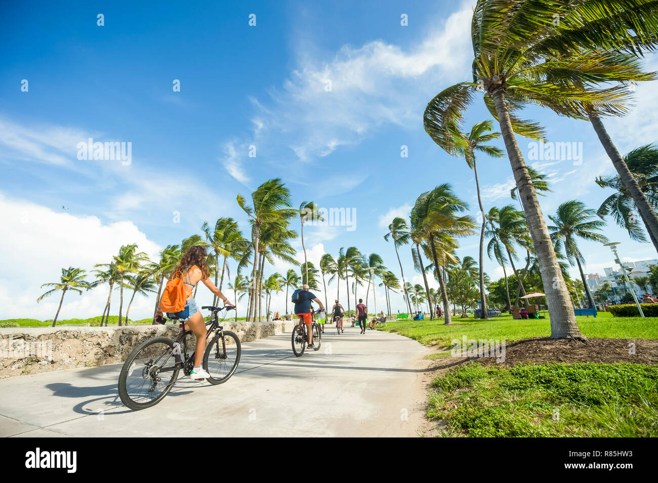 MIAMI - SEPTEMBER, 2018: Visitors and locals ride bicycles along the beachfront promenade in Lummus Park adjacent to historic Ocean Drive. Stock Photo