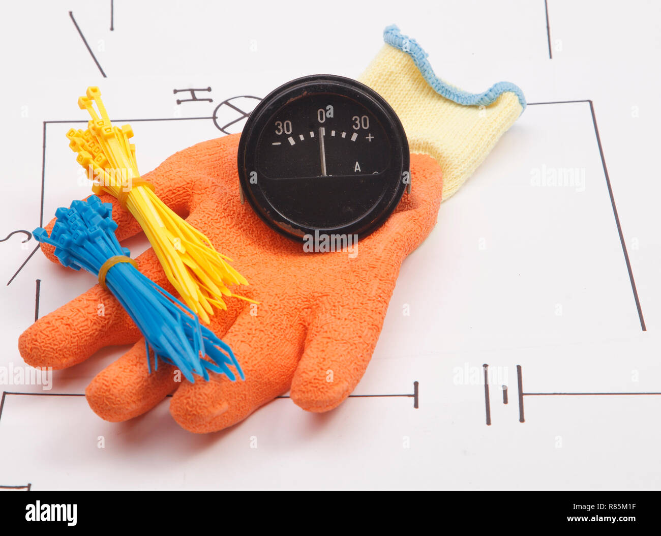 Ammeter and mounting gloves on a background of the electric scheme Stock Photo