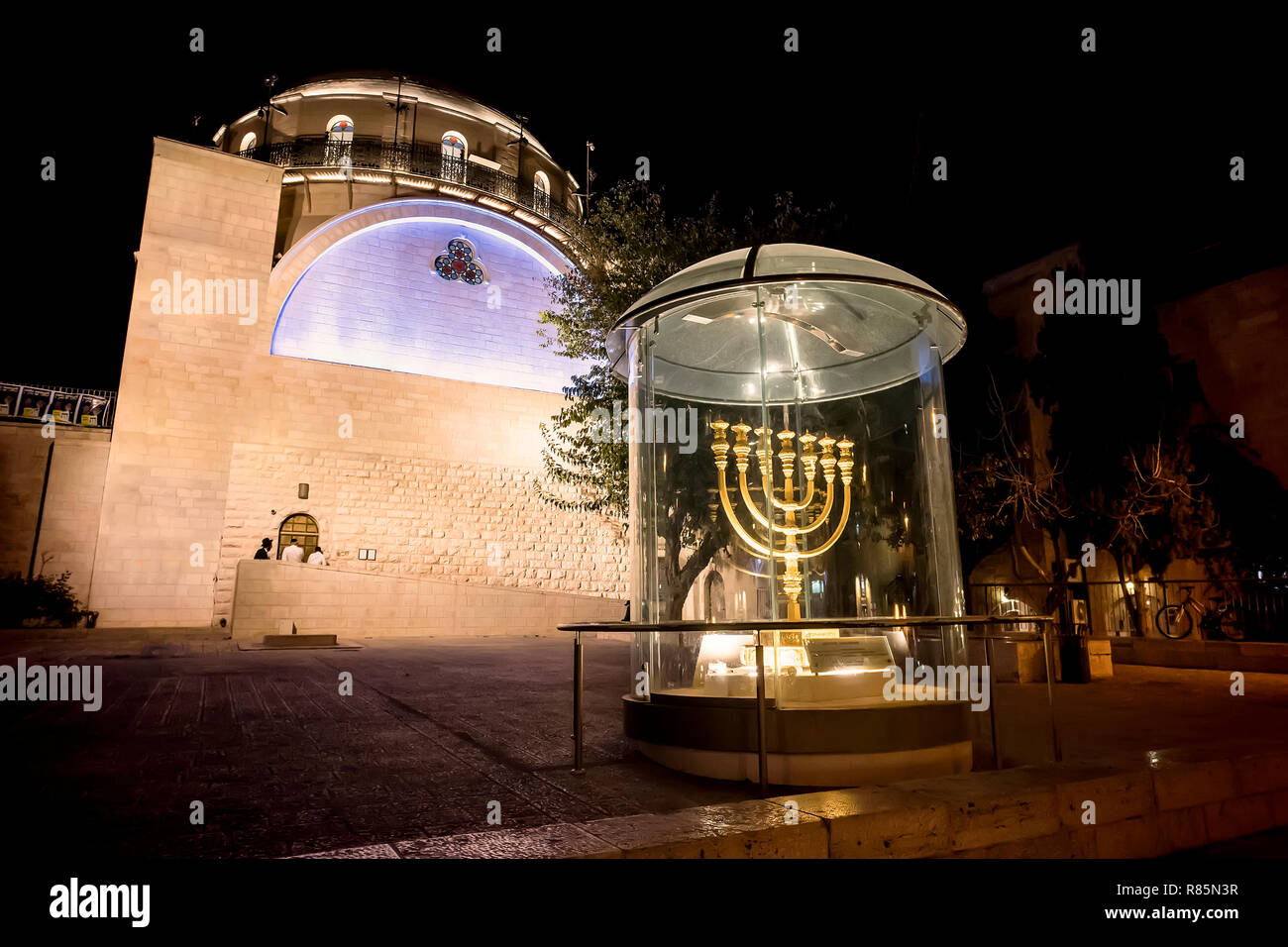 Menorah - the golden seven-barrel lamp - the national and religious Jewish emblem near the Dung Gates on the background of the synagogue Hurva at nigh Stock Photo