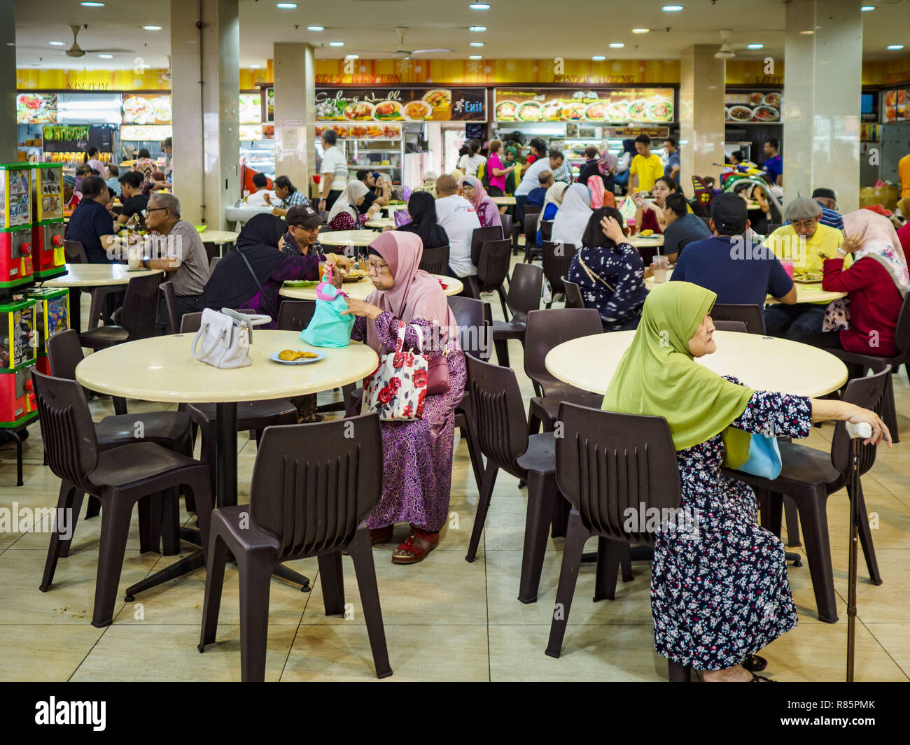 Singapore, Singapore. 13th Dec, 2018. The ''hawker stalls'' in the Joo Chiat complex in the Geylang neighborhood. Joo Chiat is a multi-tower high rise residential estate. Hawker stalls used to be street food stalls, but the government of Singapore has moved them into permanent food courts. There are hawker food stalls and retail businesses on the ground floor and residences on the upper levels. The Geylang area of Singapore, between the Central Business District and Changi Airport, was originally coconut plantations and Malay villages. During Singapore's boom the coconut plantations and Stock Photo