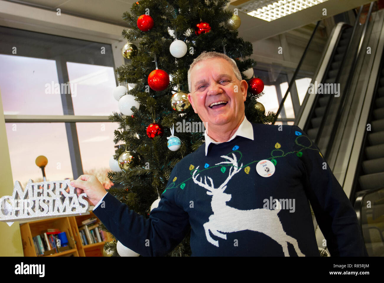 Southport, Merseyside, UK. 13th Dec, 2018. Jim McNiver (MR) displays Christmas spirit as Tesco employees join in the festive fun. Tesco employees entered into the Christmas festive spirit by supporting Save the Children's Christmas jumper day. Staff agreed to simply stick on a silly sweater and encourage donations to help save children's lives. Friday marks the seventh annual Christmas Jumper Day raising funds for charity on the woollen sartorial event of the year, Credit: MediaWorldImages/AlamyLiveNews. Stock Photo