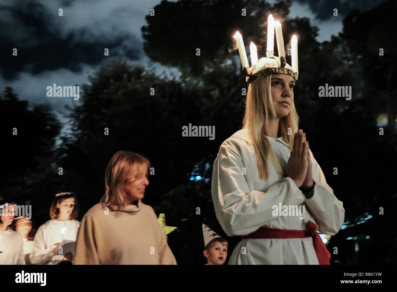 Jerusalem, Israel. 13th December, 2018. The Swedish Theological Institute (STI) in Jerusalem hosts Santa Lucia Day celebrations commemorating Lucia of Syracuse (283-304), Saint Lucy, Saint Lucia, or Sancta Lucia. The feast has become a festival of light, particularly celebrated in Scandinavian countries, where young girls traditionally dressed in white with a red sash, carry palms and wear wreaths of candles on their heads. Credit: Nir Alon/Alamy Live News Stock Photo