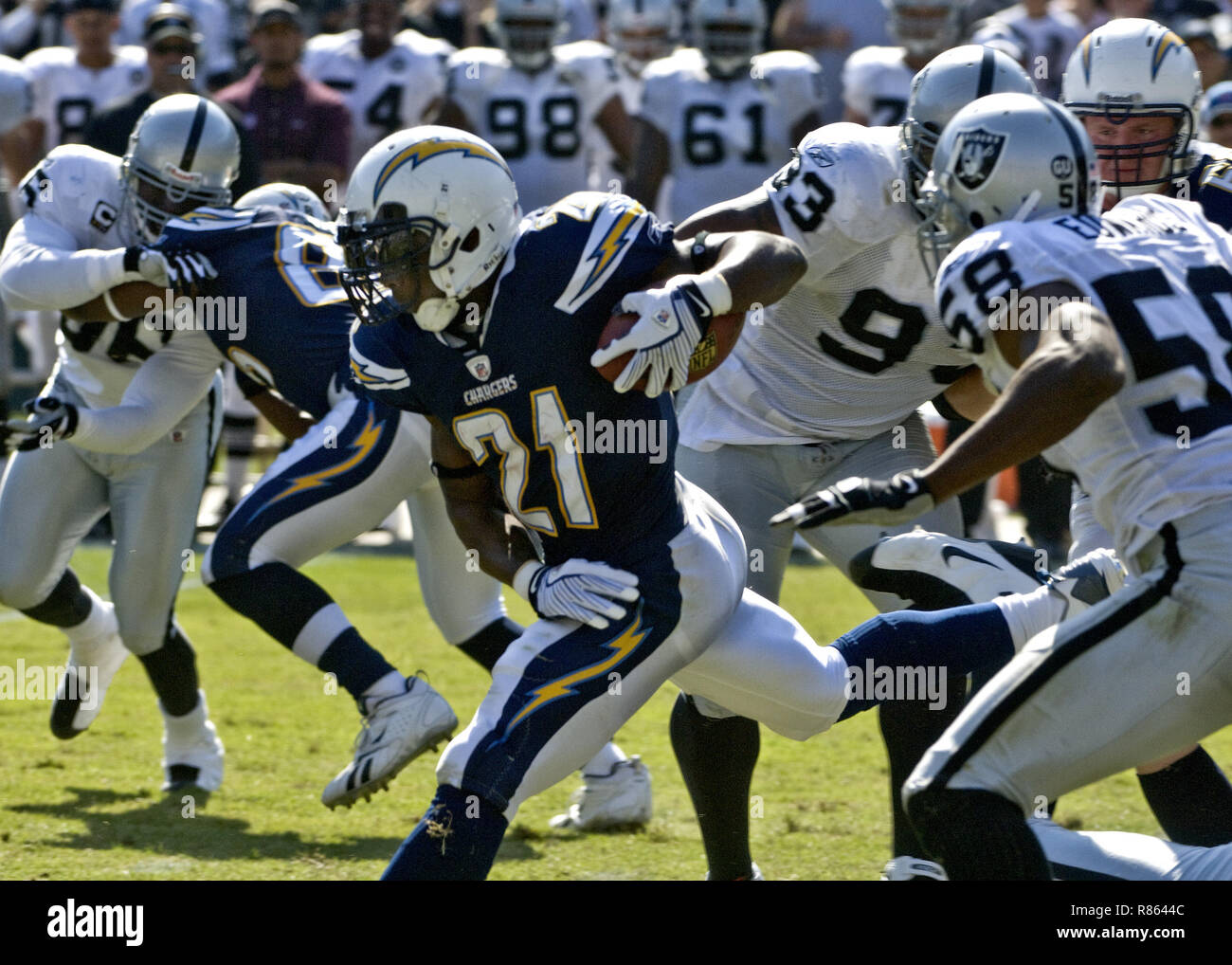 Oakland, California, USA. 28th Sep, 2008. San Diego Chargers running back LaDainian Tomlinson #21 finds a seam to run in between Oakland Raiders defensive tackle Tommy Kelly #93 and defensive end Kalimba Edwards #58 on Sunday, September 28, 2008, at Oakland-Alameda County Coliseum in Oakland, California. The Chargers defeated the Raiders 28-18. Credit: Al Golub/ZUMA Wire/Alamy Live News Stock Photo