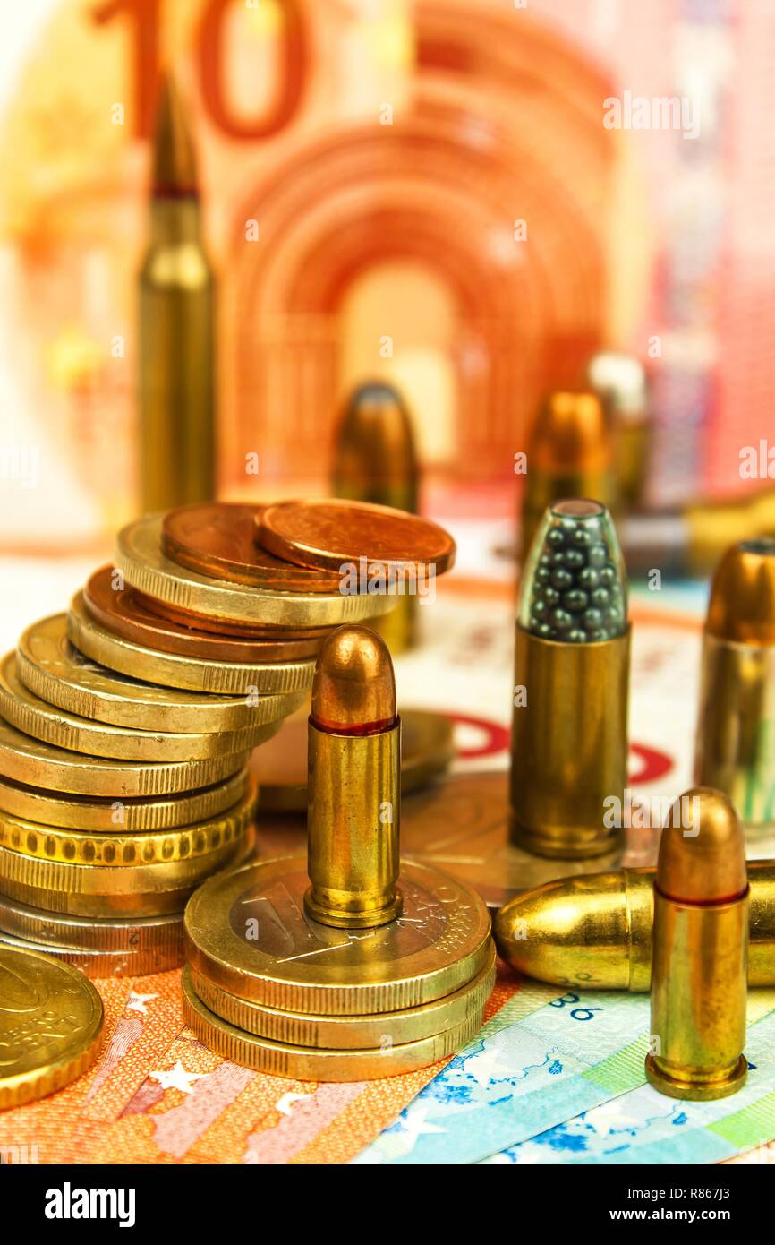 Euro coins and banknotes and cartridges of different caliber. Illegal trade in ammunition. Sale of weapons. Financing terrorism. Stock Photo