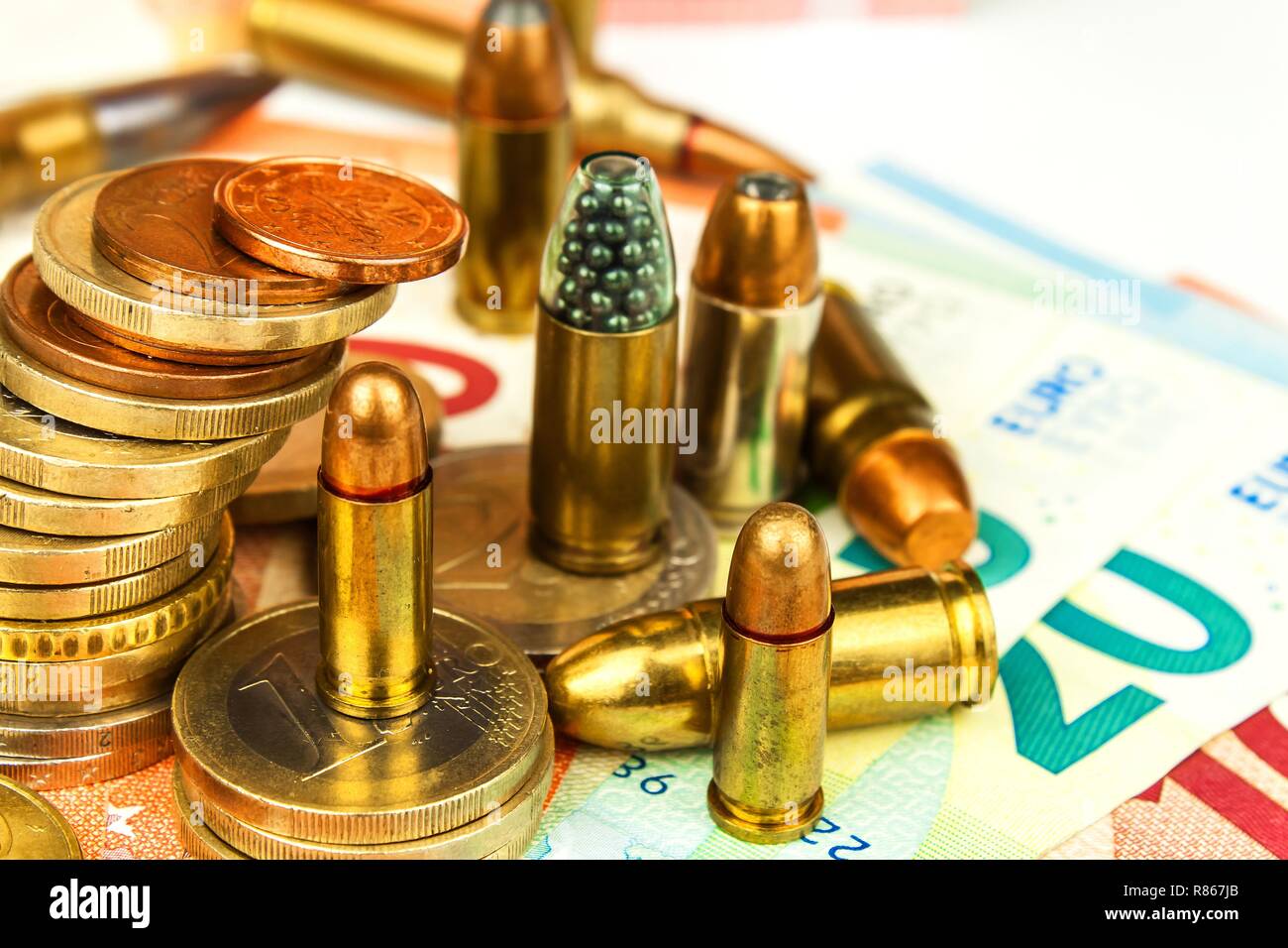 Euro coins and banknotes and cartridges of different caliber. Illegal trade in ammunition. Sale of weapons. Financing terrorism. Stock Photo