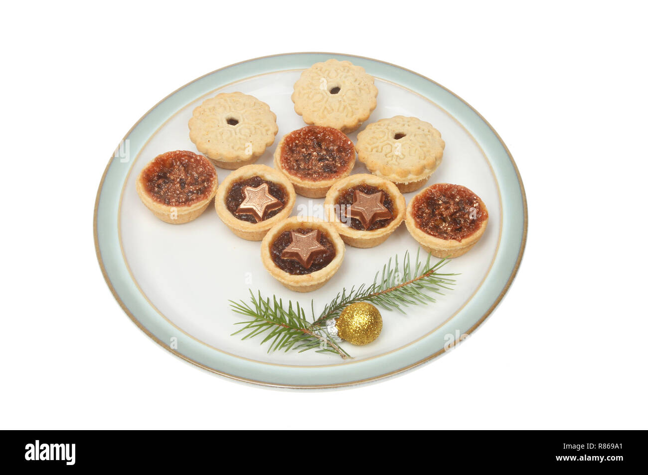 Festive mince pies on a plate decorated with pine needles and a gold ...