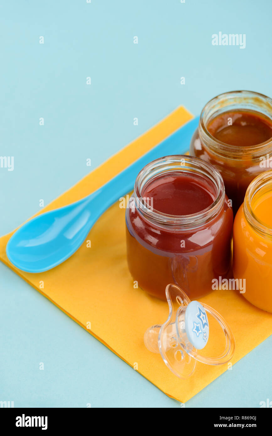 Spoon, baby food and pacifier Stock Photo