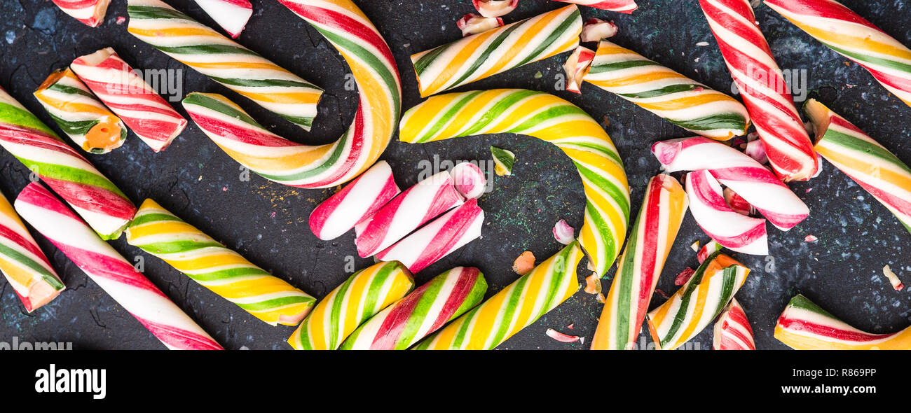 High angle view of a broken candy cane on dark background. Long wide