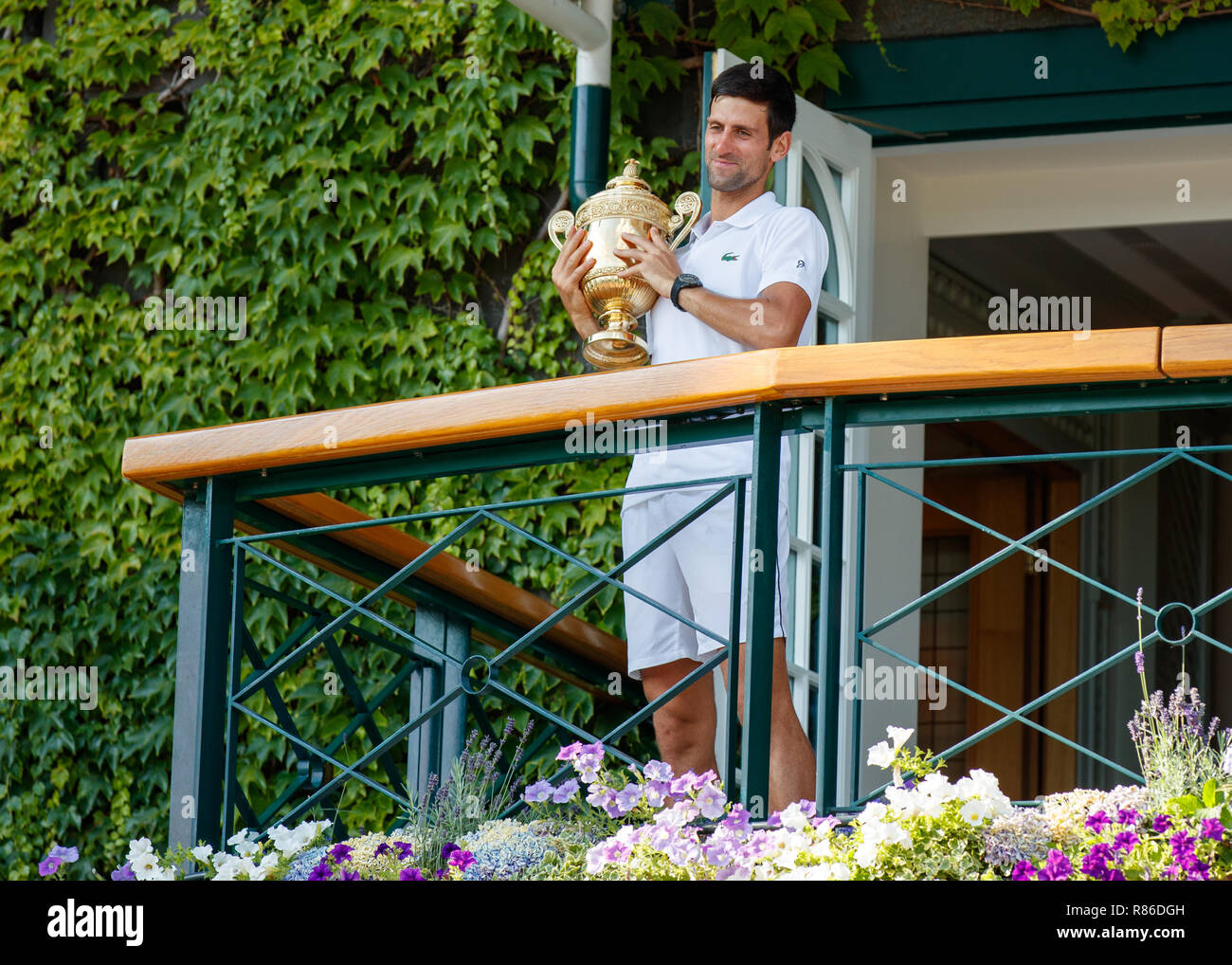 Novak Djokovic of Serbia celebrates with the trophy on Centre Court balcony during the Wimbledon Championships 2018 Stock Photo