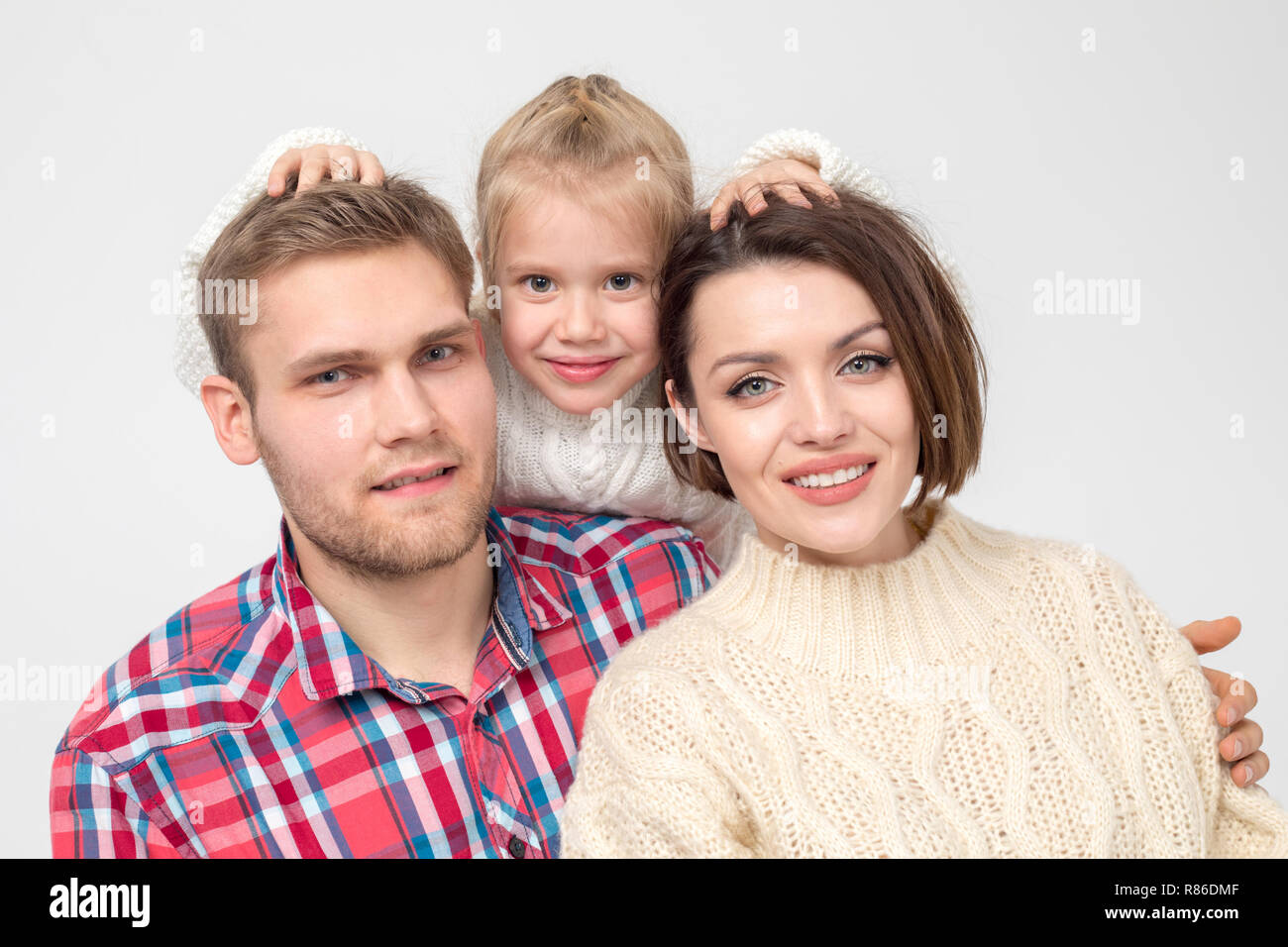 Happy family of three hugging on white background. Stock Photo