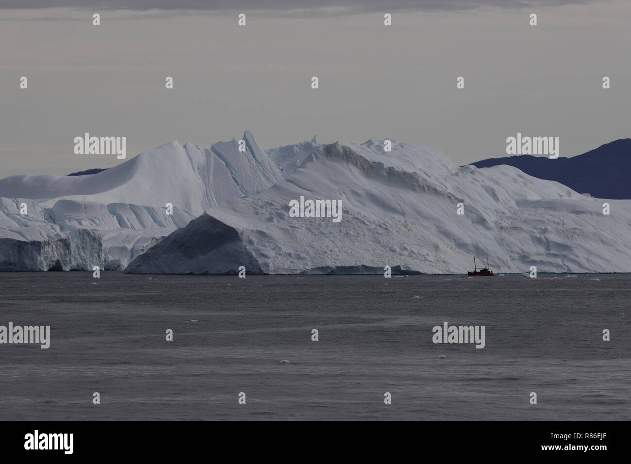 Grönland Disko Bucht: Ausflugsschiff vor einem Eisberg Stock Photo