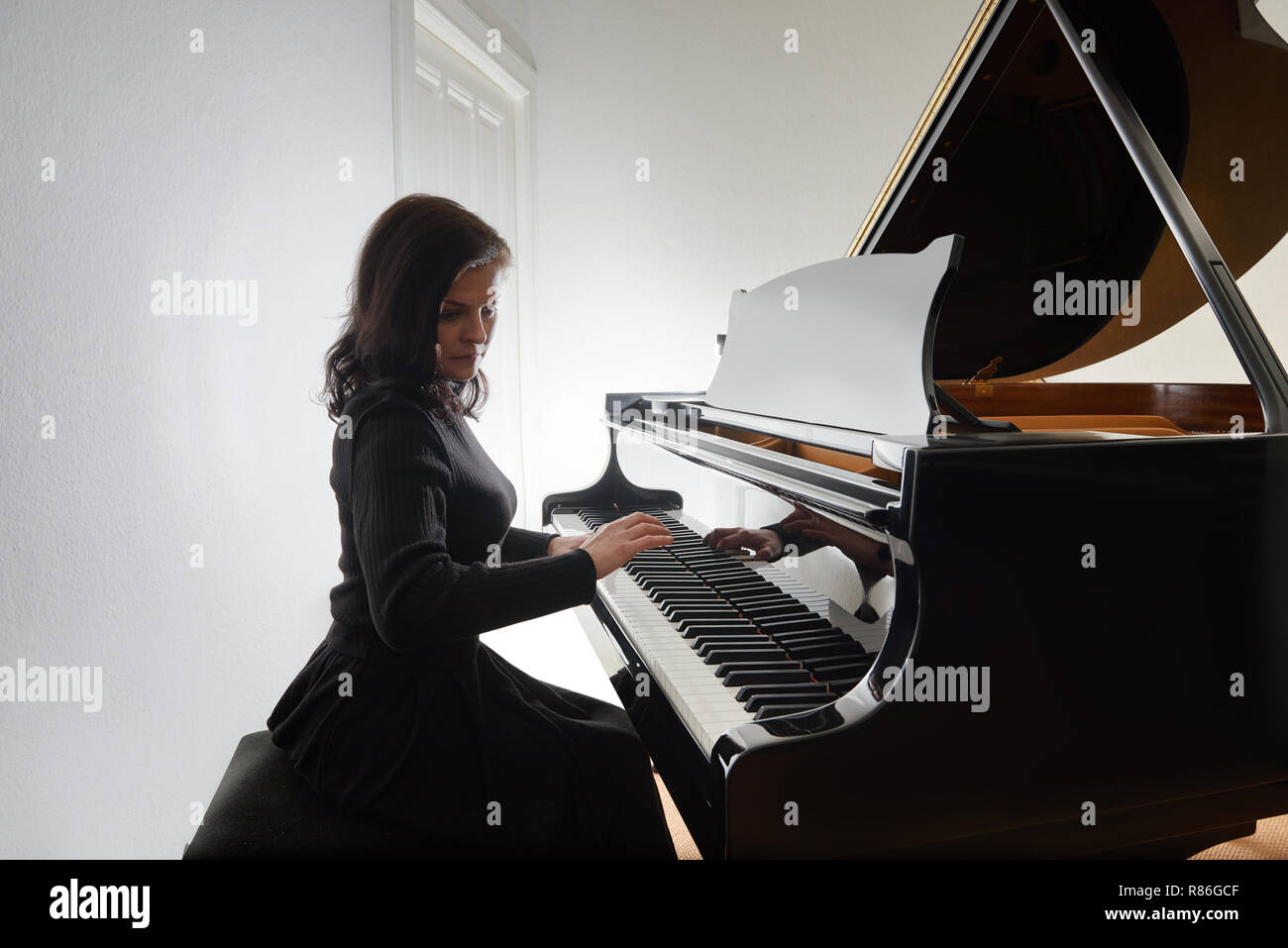 Woman playing piano alone hi-res stock photography and images - Alamy