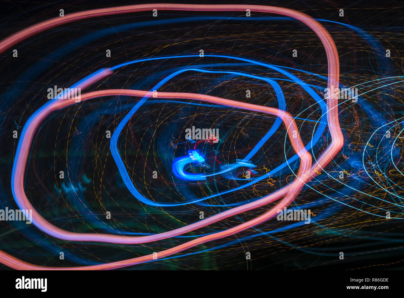 Bright abstract spiral patterns from colored light strips on a black ...