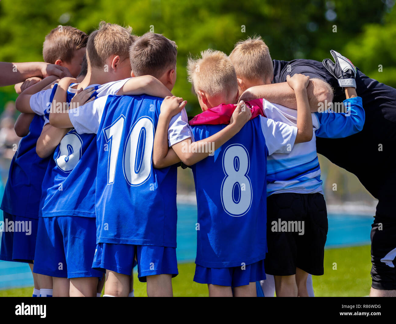 Kids Sports Team. Group of Soccer Team Players Standing Together With Coach. Coach Giving Young Sports Team Instructions. Sports Club For Kids. Coachi Stock Photo