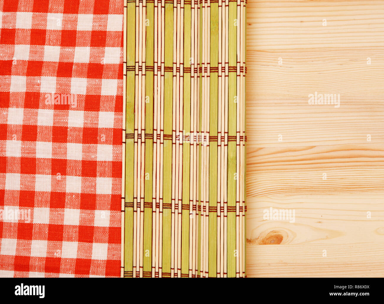 Color bamboo mat and tablecloth red and white checkered wavy on wooden table Stock Photo