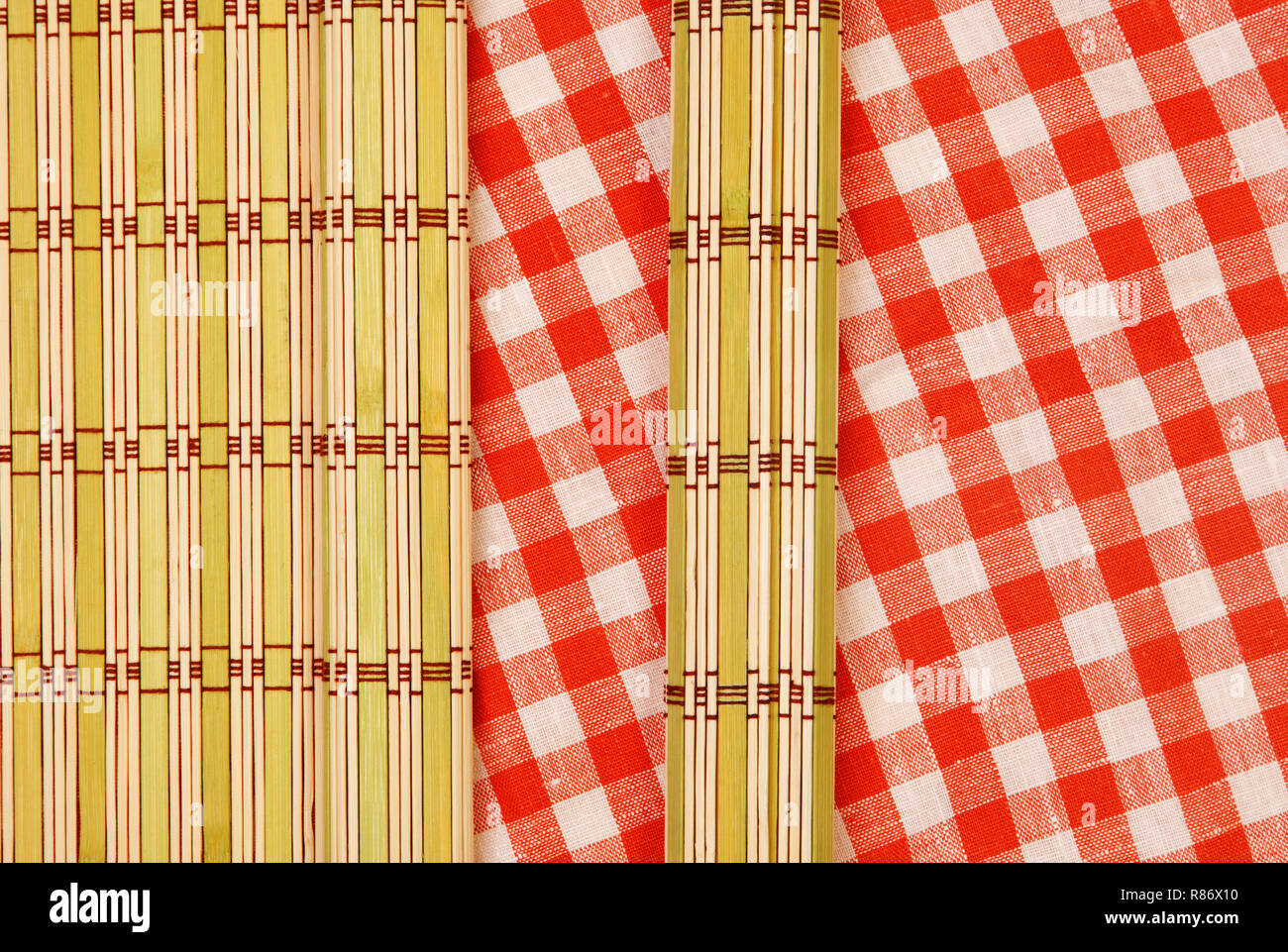 Color bamboo mat and tablecloth red and white checkered wavy on wooden table Stock Photo
