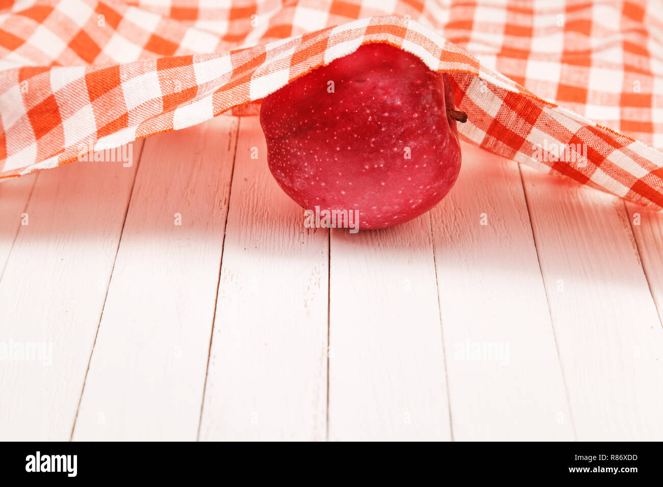 Red apple on white table covered with a tablecloth Stock Photo