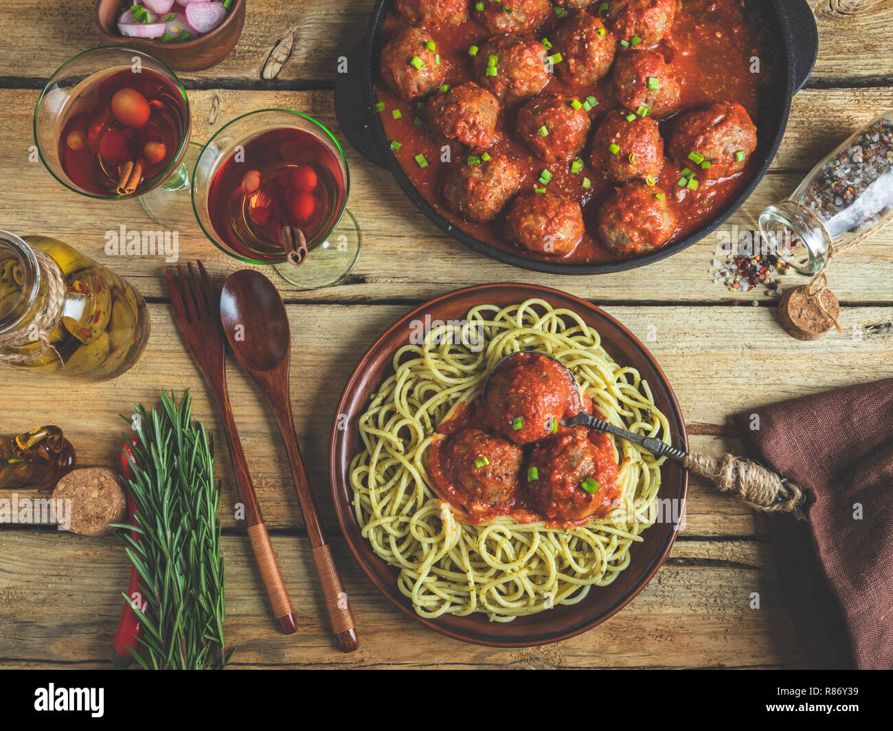 Homemade meatballs in tomato sauce with pasta on a plate. Frying pan on a wooden surface Stock Photo