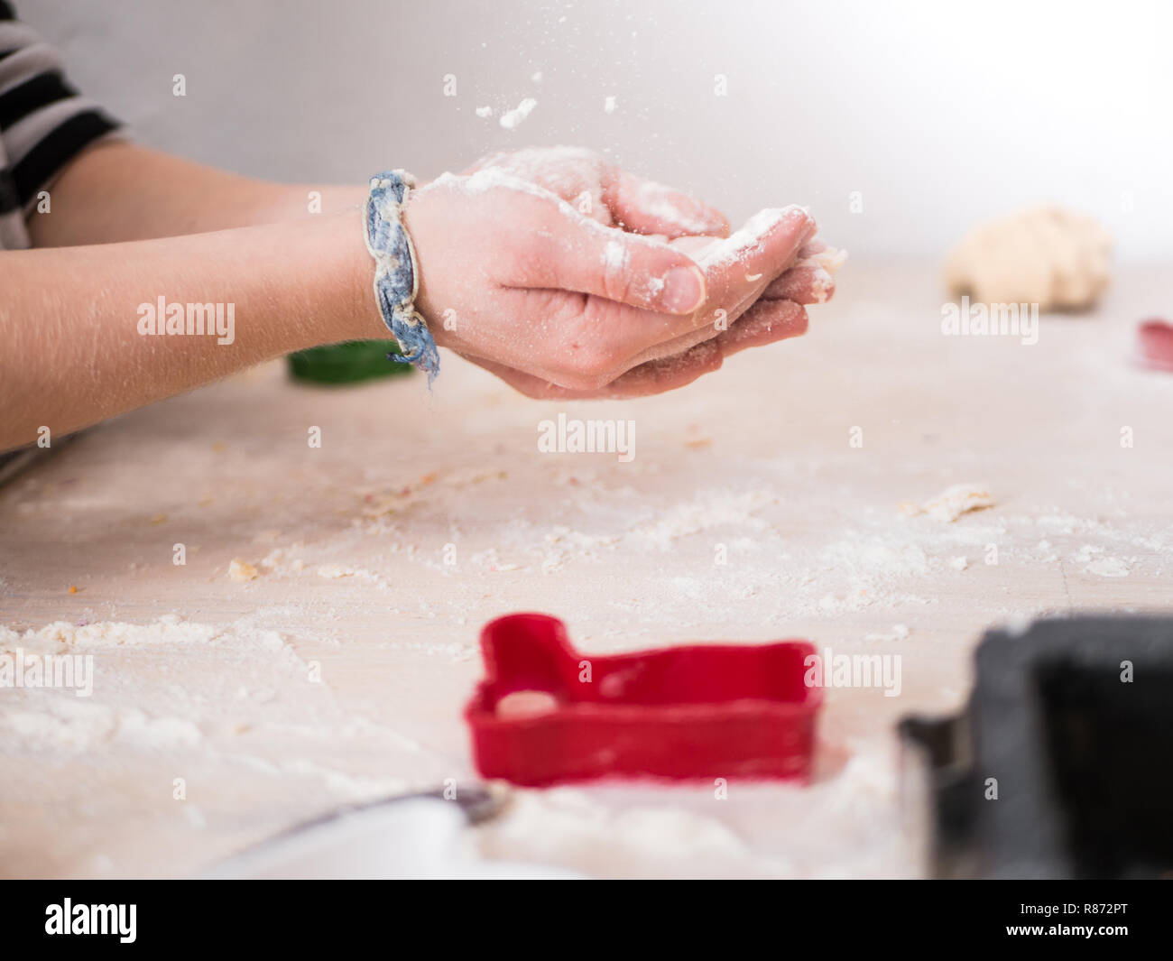 Christmas Bakery: Little Girl holding up her hands for flour Stock Photo