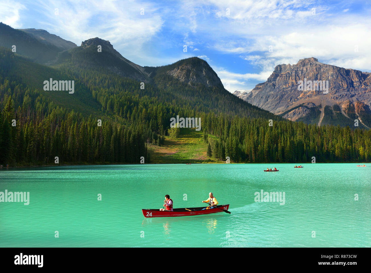 Banff, Canada - Sep 10th 2018 - A mature couple having fun in a kayak in the green color lake Emerald with beautiful pine trees in the background in C Stock Photo