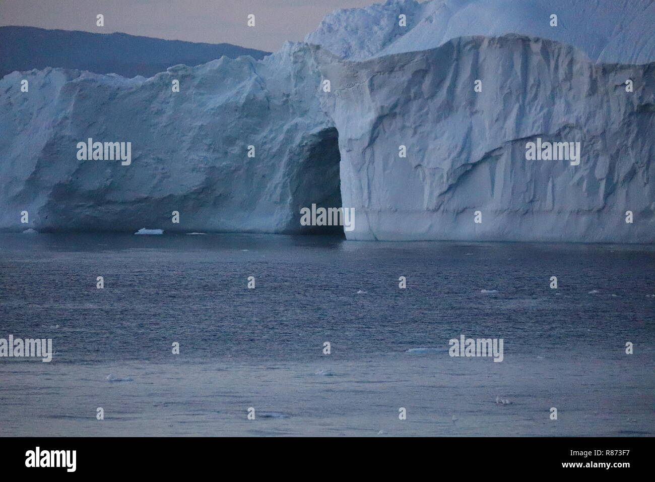 Ilulissat Eisberge am Abend Dieser Koloss zeigt beim Passieren ein Gletschertor. Stock Photo