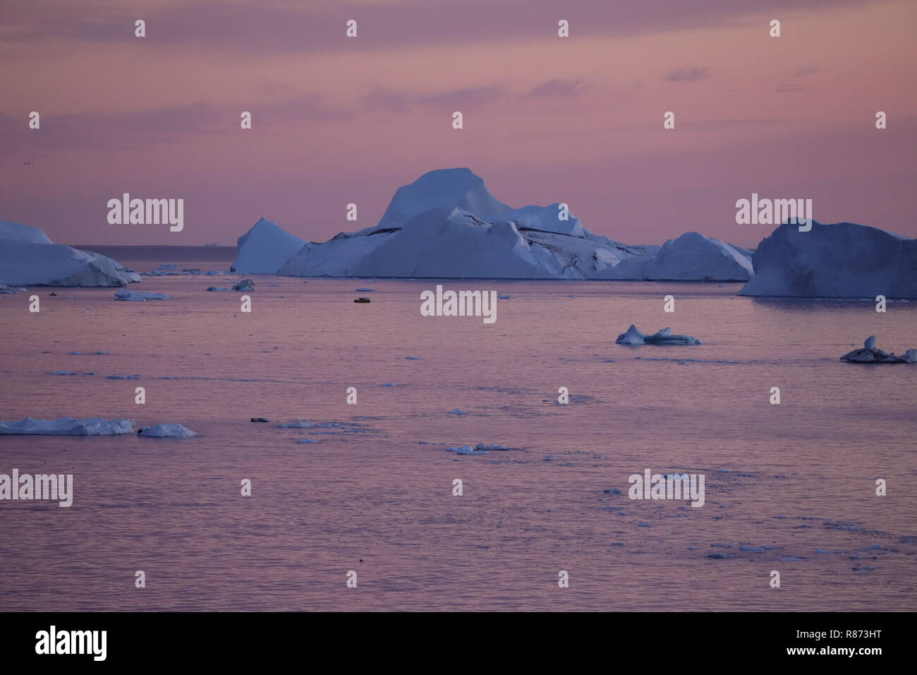 Ilulissat Eisberge am Abend: Das Abendrot wird überlagert vom Zauber der Blue Hour. Stock Photo