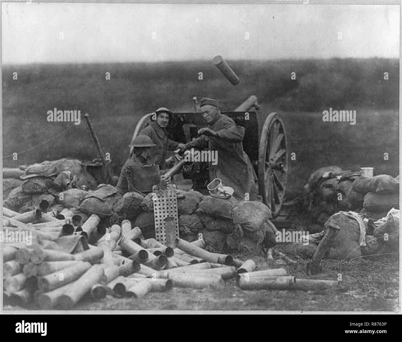 Capturing St. Mihiel Salient- 3 soldiers operating a cannon- pile of empty cannon shell casings in foreground. Stock Photo