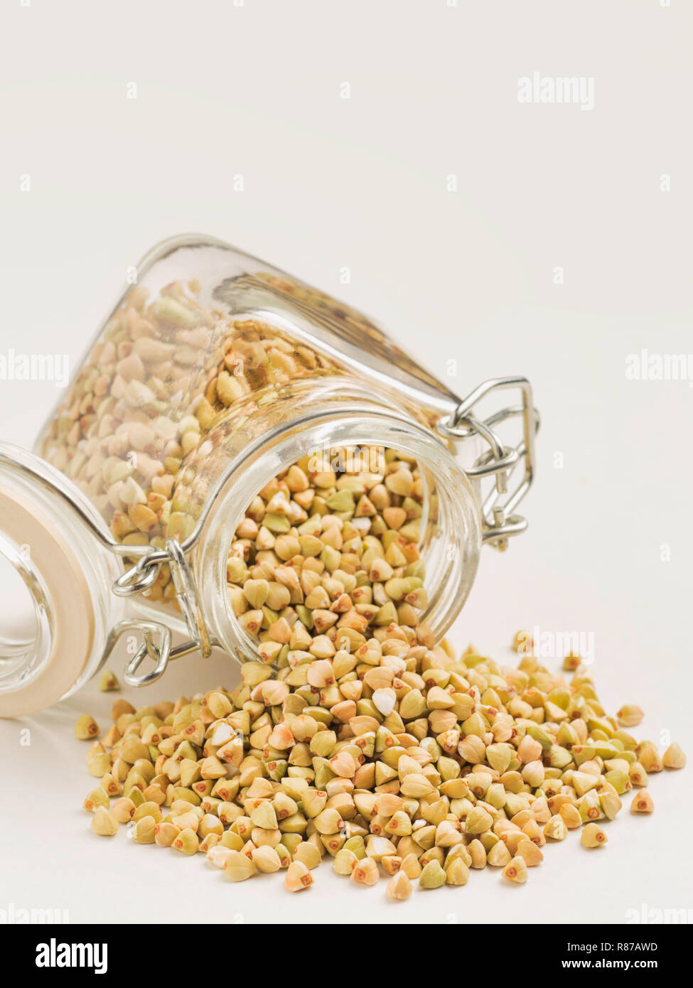 Raw green buckwheat in bank on white background. Vertical. Copy space. Healthy food and diet concept Stock Photo