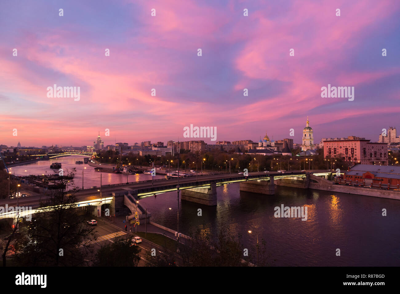 Evening, twilight and night view, red sunset over Moskva river and red skies, New monastery of the Saviour and Novospasskiy Bridge in Moscow, Russia. Stock Photo