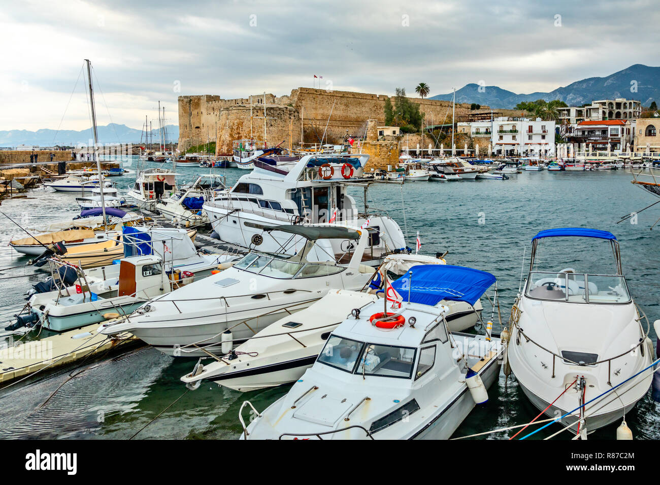 Kyrenia or Girne  historical city center, view to marina with many yachts and boats with Venetian castle and mountains in the background, North Cyprus Stock Photo