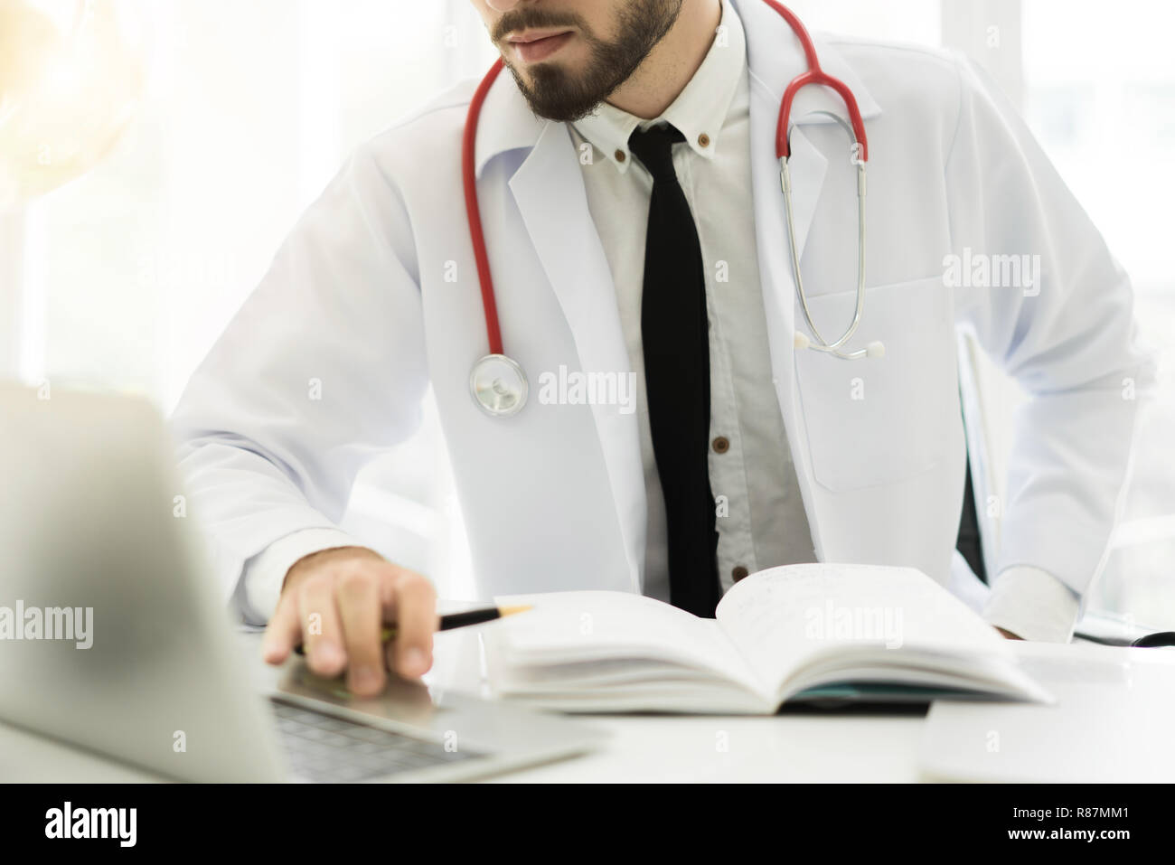 Doctor using laptop and electronic medical record (EMR) system. Digital database of patient's health care and personal information on computer screen. Stock Photo