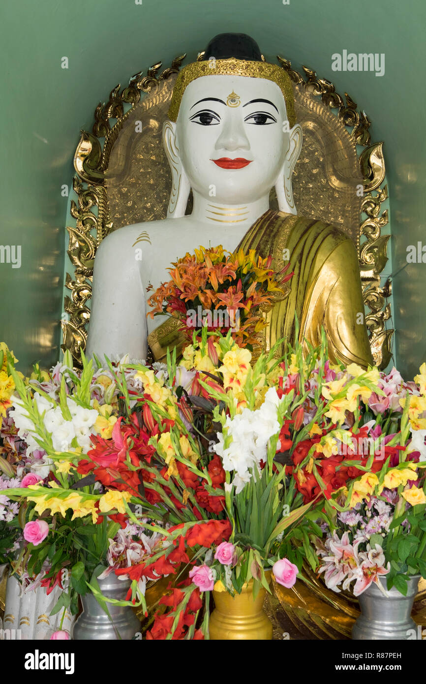 Buddha with fresh flowers the big Shwedagon Pagoda in Yangon, Myanmar. Stock Photo