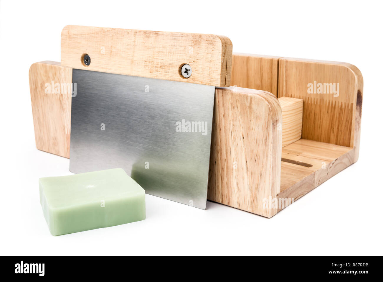 Wooden soap cutting tool with handmade soap bar on side on the white
