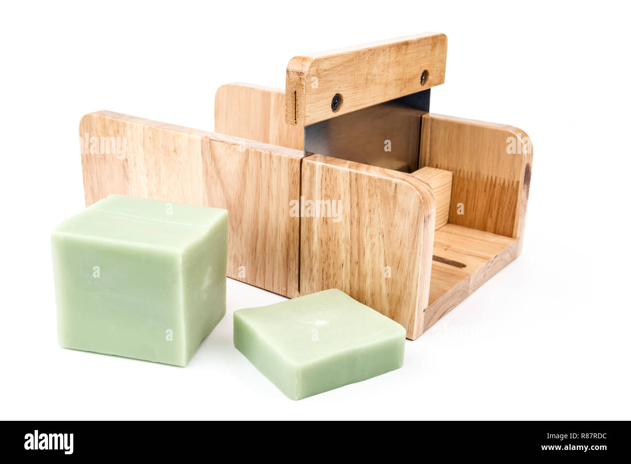 Wooden soap cutting tool with handmade soap loaf and bar on side on the
