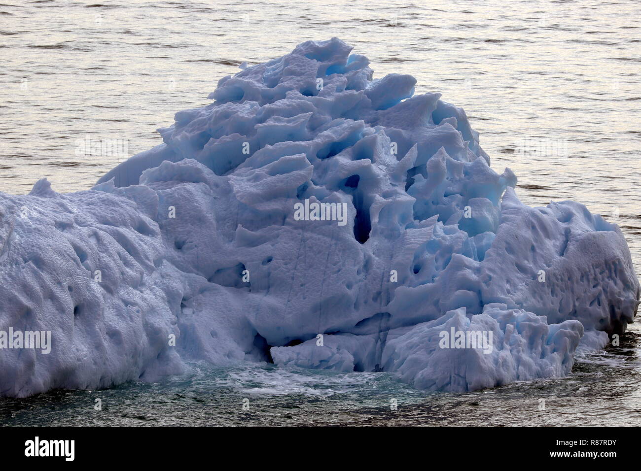 Grönland Disko Bucht: In diesen Eisberg haben Sonne und Wind schon ein paar Löcher gebohrt. Stock Photo