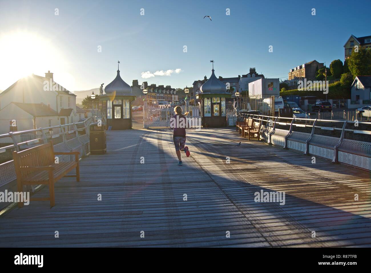 A young female runner gets some exercise on Bangor Pier at dawn, Bangor, Gwynedd, North Wales, UK Stock Photo