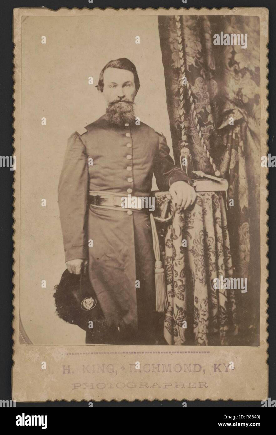 Captain John Wilson of Co. C, 8th Kentucky Infantry Regiment (Union), in uniform with sword; revolver and book rest on table) - H. King, Richmond, Ky., photographer Stock Photo