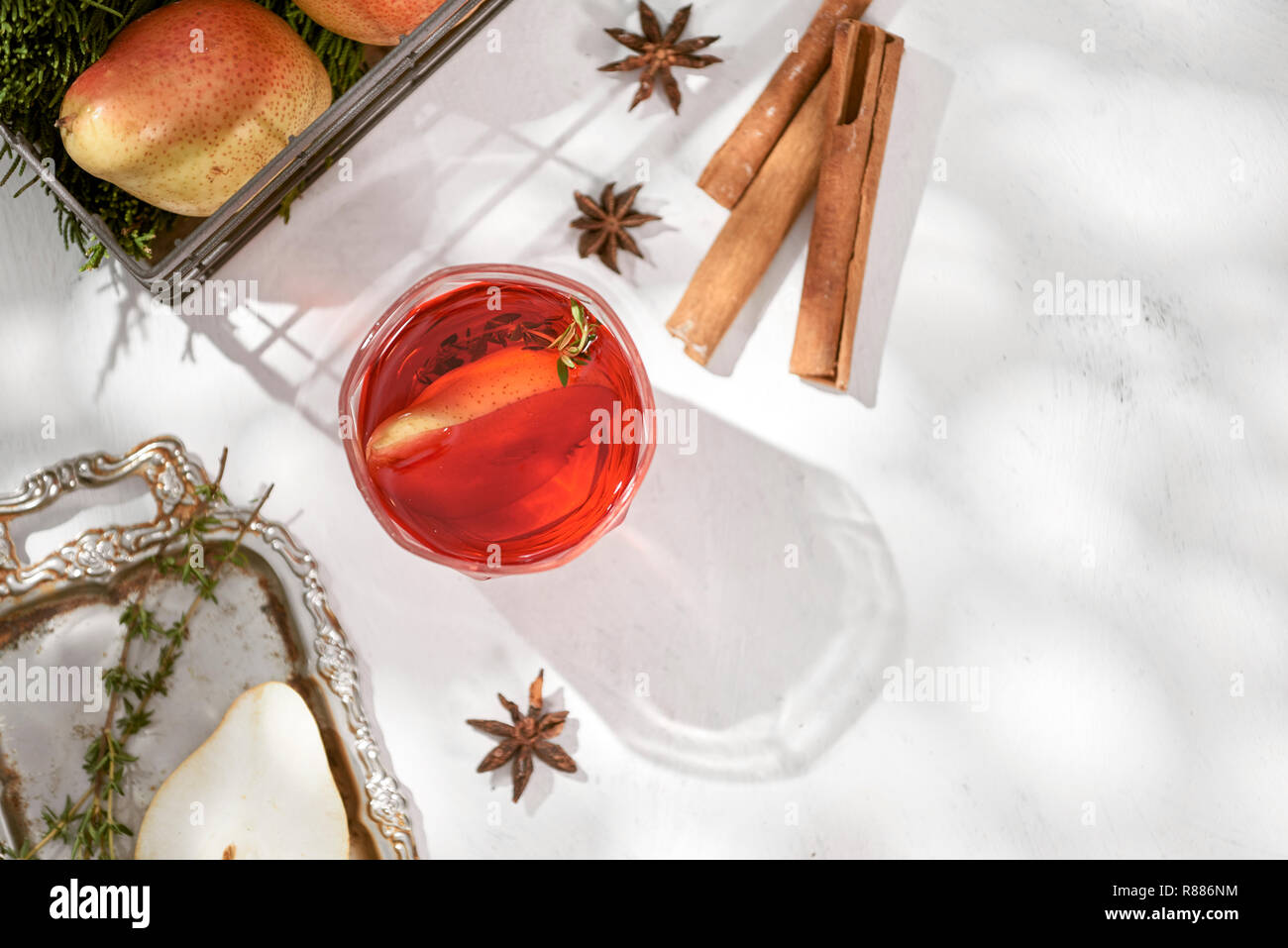 Delicious spicy hot mulled red wine with cinnamon, star anise and slice pear served in a carafe and glass for a cold winter evening or festive Christm Stock Photo