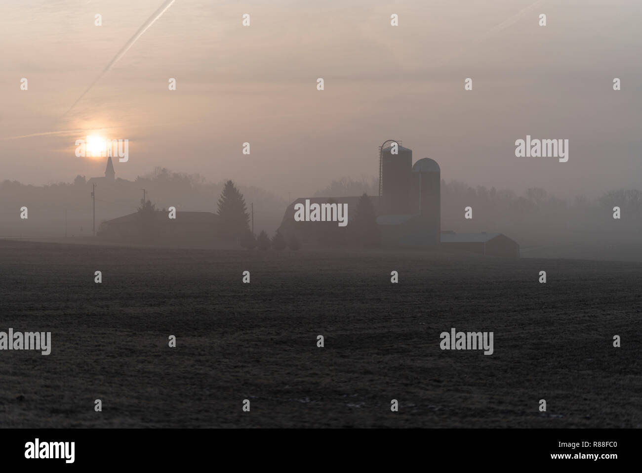 Wisconsin farm sunrise during a cold and foggy morning. Stock Photo