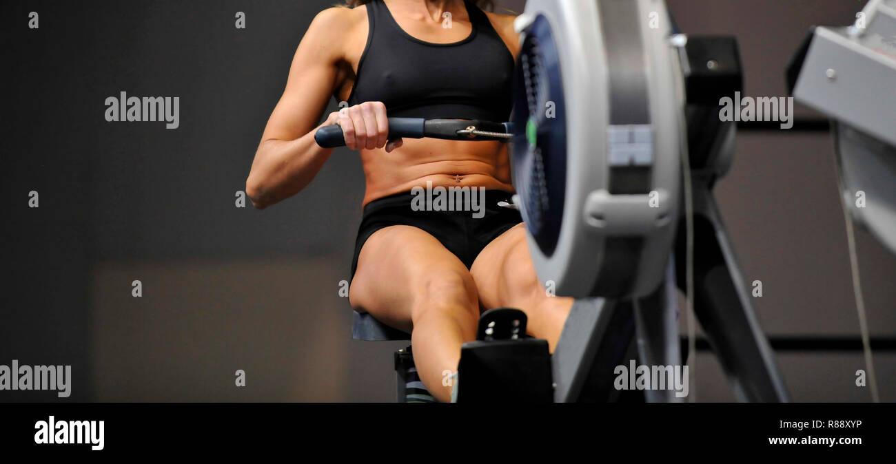 Indoor Rower Crossfit Powerful attractive muscular woman CrossFit trainer do workout on ...